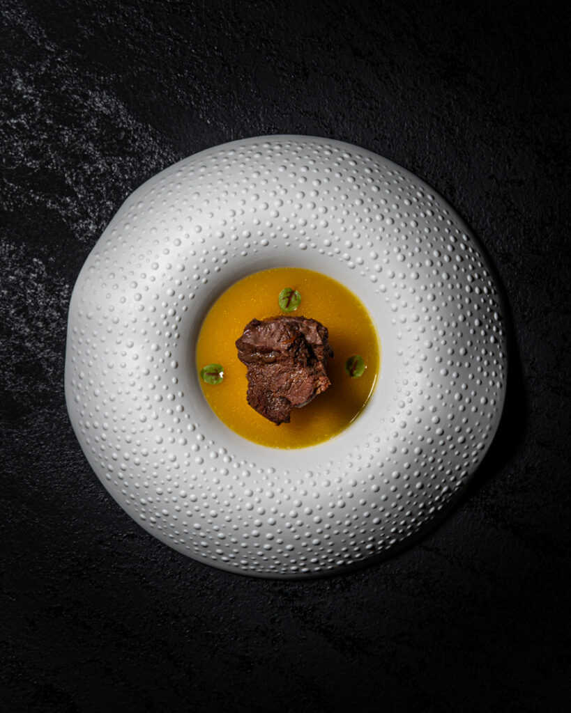 Guancia di cavallo Wen Huo servita con salsa gialla su piatto bianco