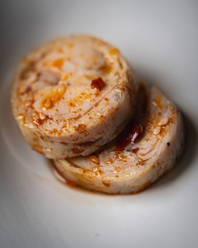 Pollo piccante che mette l’acquolina servito a rotolino con olio rosso