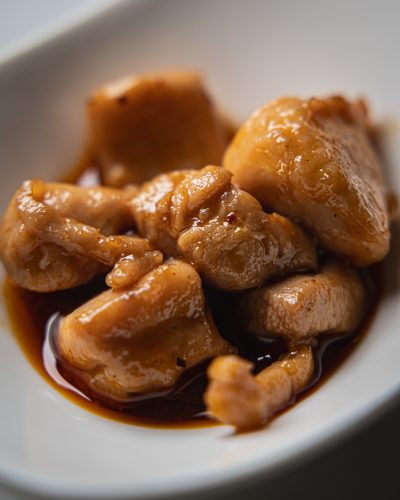 Coniglio alla scorza di mandarino servito in ciotola bianca